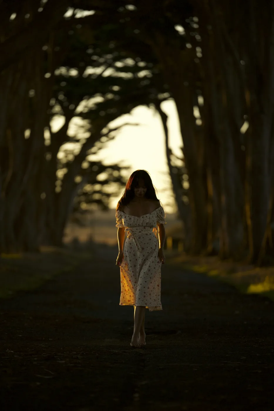Catalina caminando entre los pinos con luz cálida